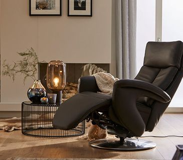 Relaxsessel aus Leder neben einem modernen Beistelltisch mit einer Lampe