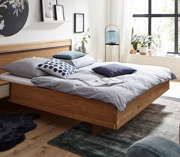 Bettgestell in Holzoptik mit optisch passenden Nachttisch und Kommode in Schwebeoptik