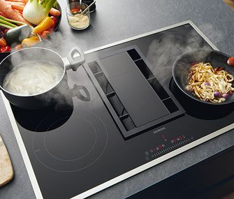 Dampf von kochenden Töpfen wird von Muldenlüfter abgesaugt