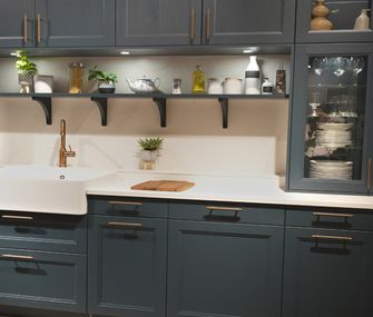 Modderne Landhausküche in dunklem Petrol mit messingfarbenen Griffen und Marmorarbeitsplatte