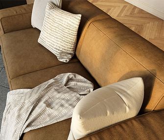 Nahaufnahme des olivgrünen Sofas mit weißen und beigefarbenen Kissen und einer Decke