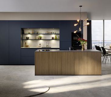 Moderne Inselküche mit schwarzer Küchenzeile und Kücheninsel in Holzoptik.