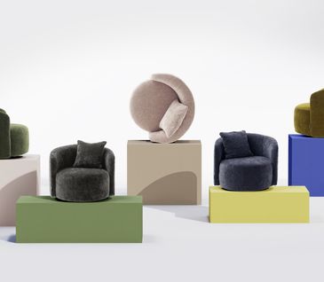 Kunstvolle Anordnung verschiedenfarbiger Sessel vor weißer Wand.