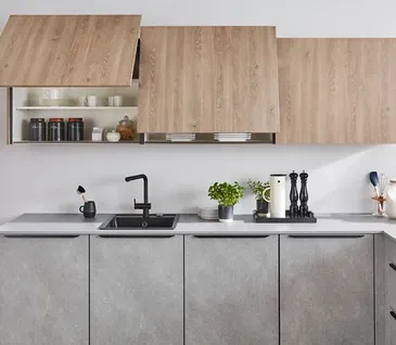 Küche in L-Form in hellgrauer Betonoptik mit Küchenschränken aus Holz.