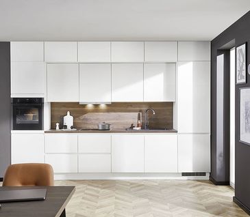 Küchenzeile mit grifflosen Fronten in strahlendem Weiß.