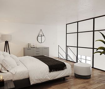 Schlafzimmer mit Boxspringbett, kleiner Kommode und Hocker vor dem Bett