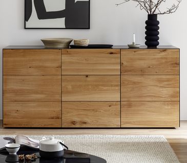 Sideboard aus Massivholz und schwarzem Metall mit moderner Deko und Vase.