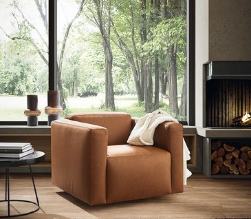 Hellbrauner Sessel in natürlich eingerichtetem Wohnzimmer.
