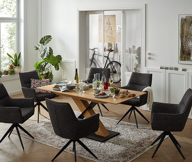 Braune Armlehnstühle um einen Massivholztisch