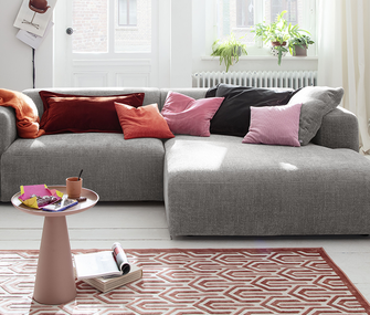 Ecksofa in grau von Raum.Freunde mit bunten Kissen