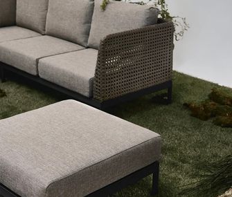 Hellgraues Outdoor Lounge-Sofa mit passendem Hocker.