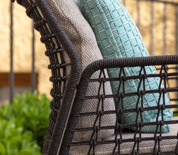 Detailbild von Lehne und Rückenlehne eines Gartenstuhls aus Rope und mit hellgrauen Sitzpolstern.