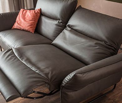 Elegant und robust: Semi-Anilin ist der Allrounder unter den Lederarten Dunkelbraunes 2-Sitzer Ledersofa mit Relaxfunktion und rotem Kissen