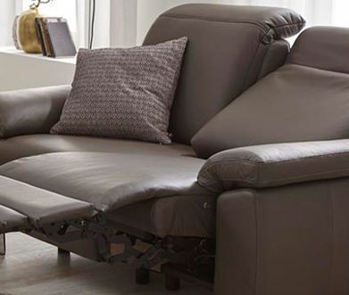 Braune Funktionscouch aus Echtleder mit aufgebauter Relaxfunktion und gemustertem Kissen