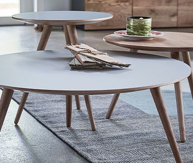 Drei unterschiedlich hohe Beistelltische mit runden Tischplatten und schrägen Füßen