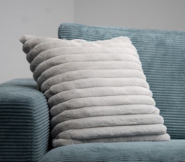 Hellblaues Sofa mit silberfarbenem Kissen dekoriert.