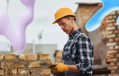 A construction worker in a hard hat and overalls lays bricks on a building site, with purple and blue abstract shapes overlaid.