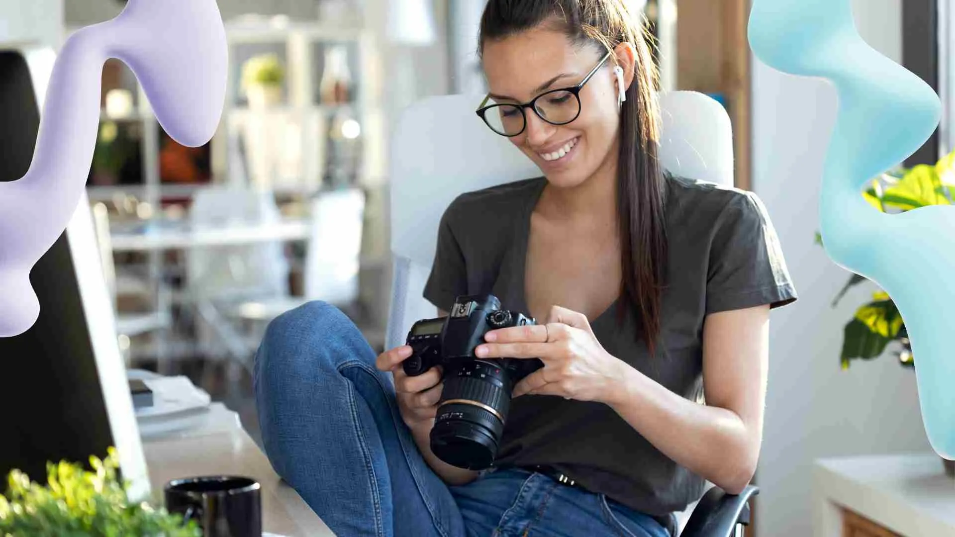 Smiling woman in glasses and earbuds reviews photos on a DSLR camera in a bright office, with decorative purple and blue shapes.