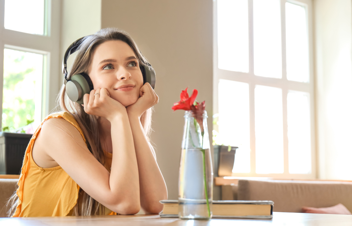 The image shows a girl listening to an audiobook wearing black headphones. She is smiling