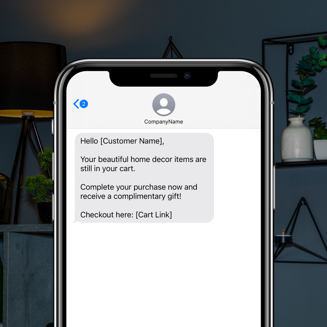 Example of an Abandoned Cart SMS on a smartphone screen, reminding a customer about home decor items left in their cart with a complimentary gift offer.