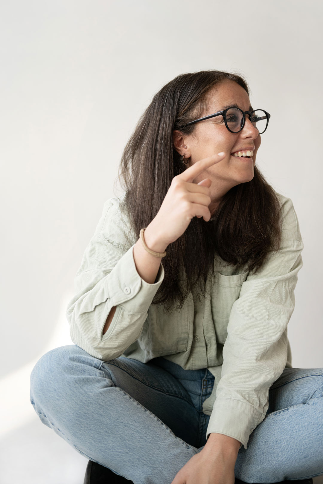 Woman smiling, looking and pointing right