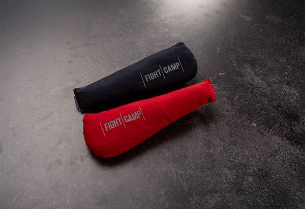 Two boxing gloves fresheners, one blue and one red, with "FIGHT CAMP" printed on them, placed on a dark textured surface.