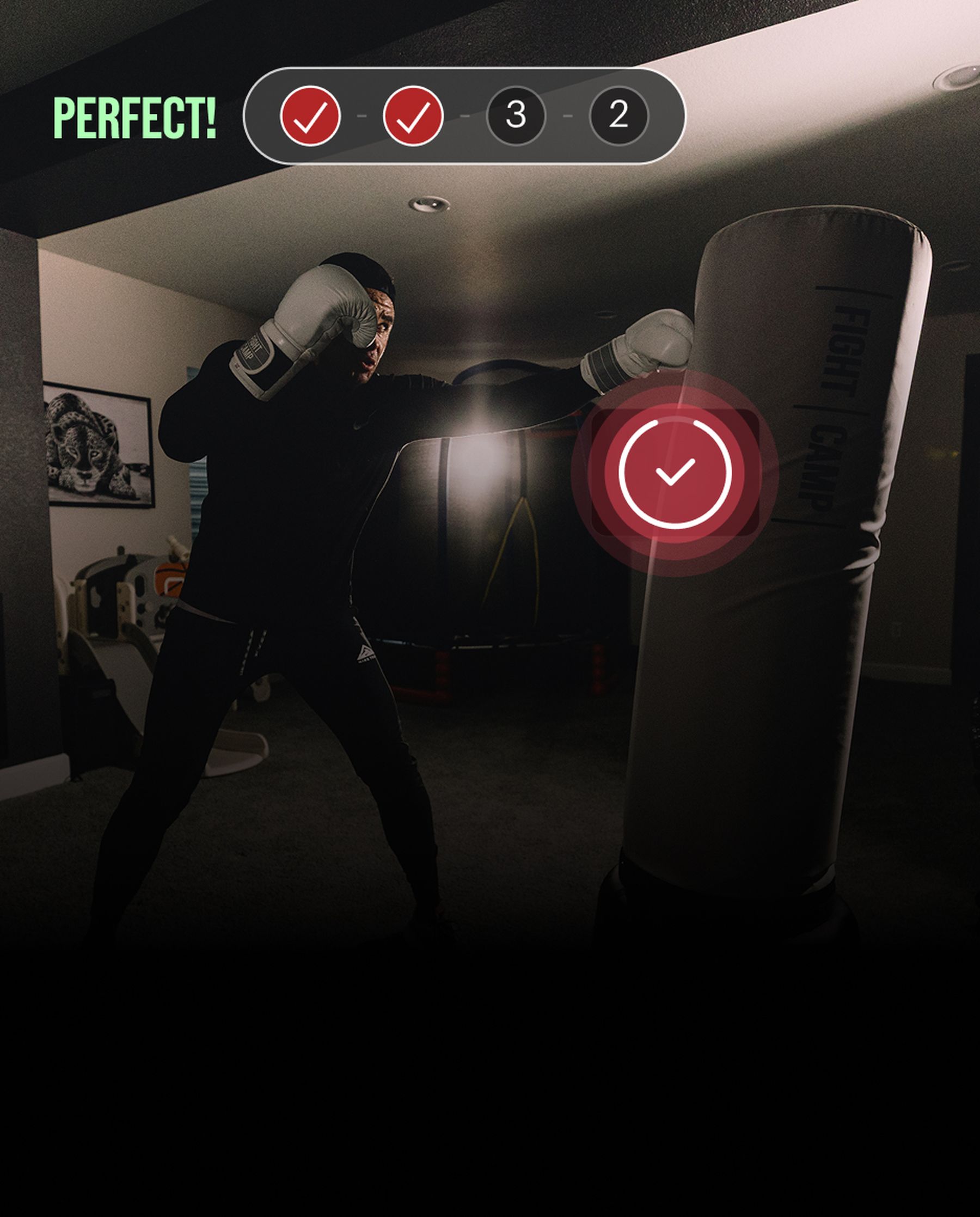 Person in dark room boxing a punching bag, wearing white gloves. Screen displays "Perfect!" with checkmarks and numbers "3-2."