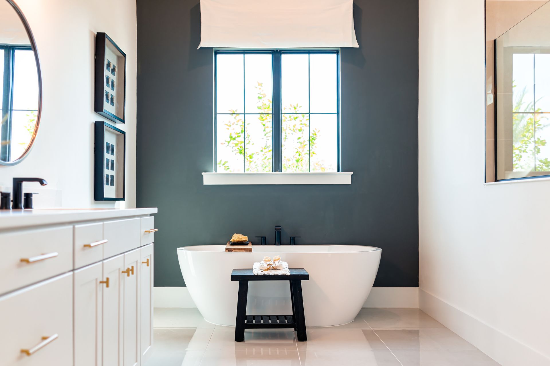 A bathroom with the focus on a white tub with a blue accent wall