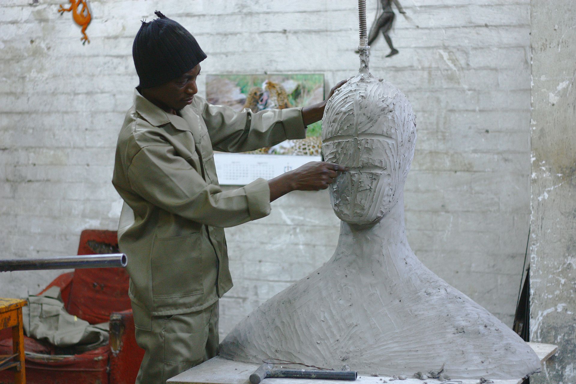 Carving a face into a paper mache type sculpture with a small art tool