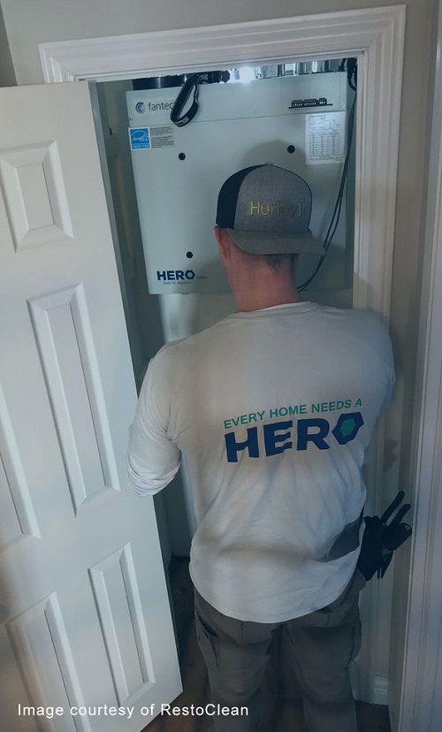 Man installing a HERO Fresh Air Appliance