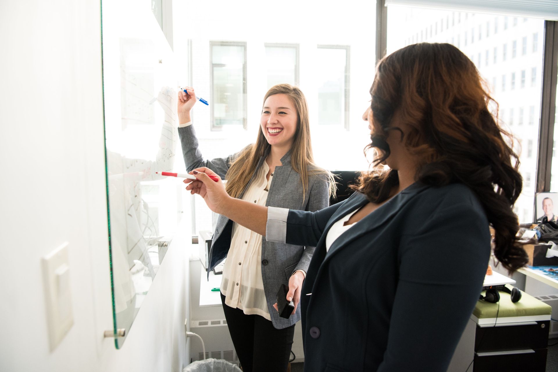 To ladies at work writing on a white board