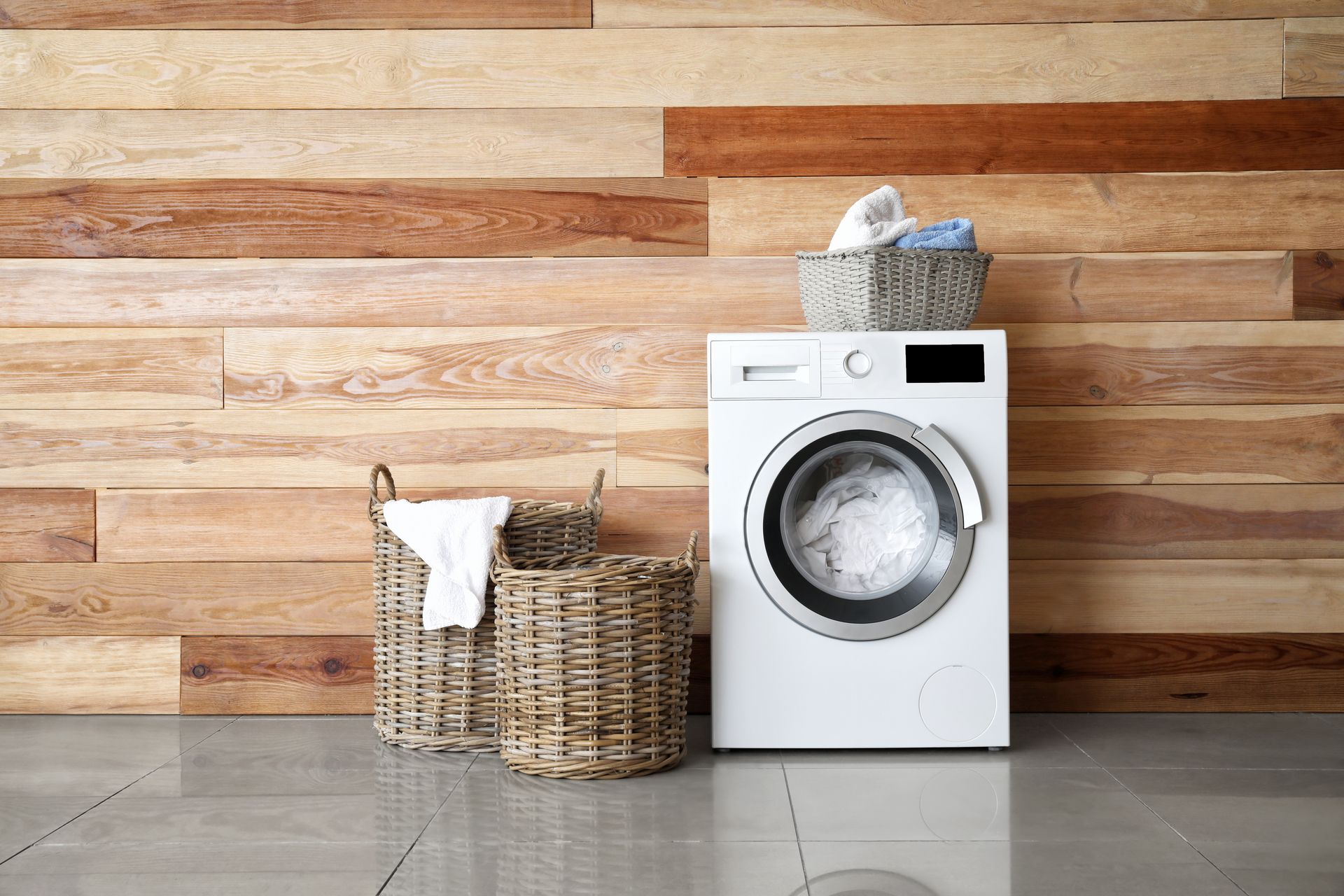 Image of a dryer with clothes baskets against a wood wall