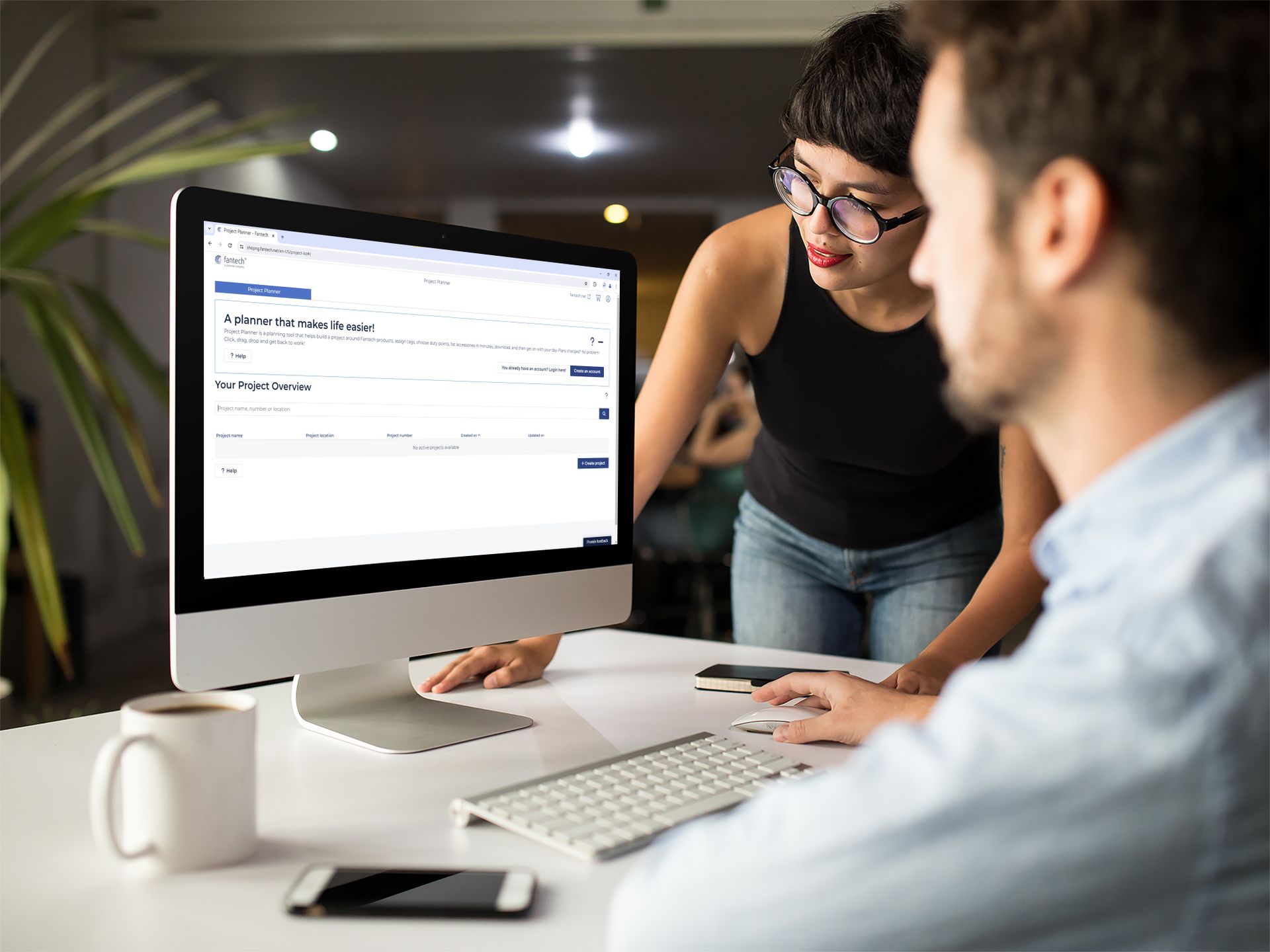 Woman showing something to a man on a computer