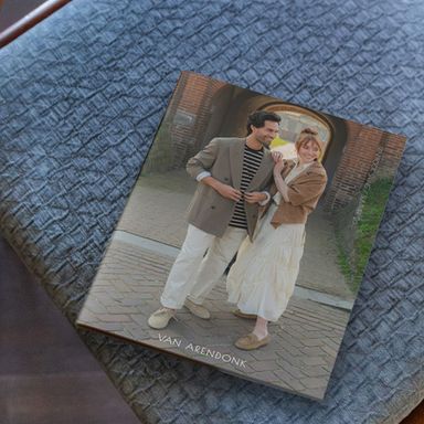 A magazine featuring a man and woman in casual attire smiling and holding hands, placed on a textured blue surface.