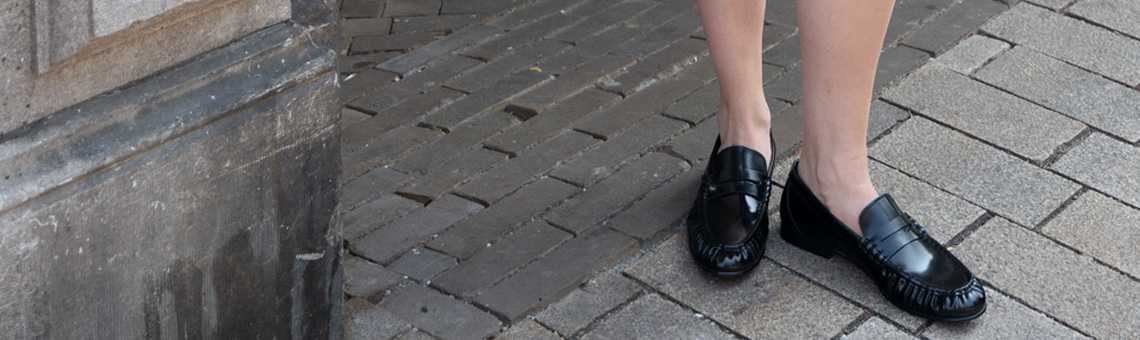 vrouw-die-staat-op-straat-penny-loafers-met-naad-posa