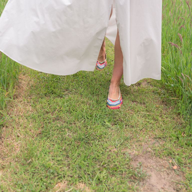 vrouw met raffia  ballerina rennend over gras