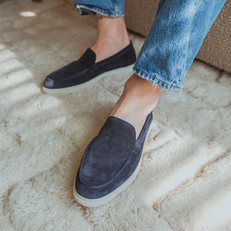 Donkerblauwe suède herenloafers onder blauwe jeans