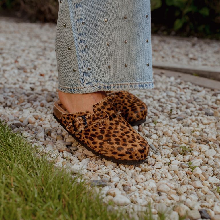 Close-up Scholl clogs met kurk zool op kiezelsteentjes