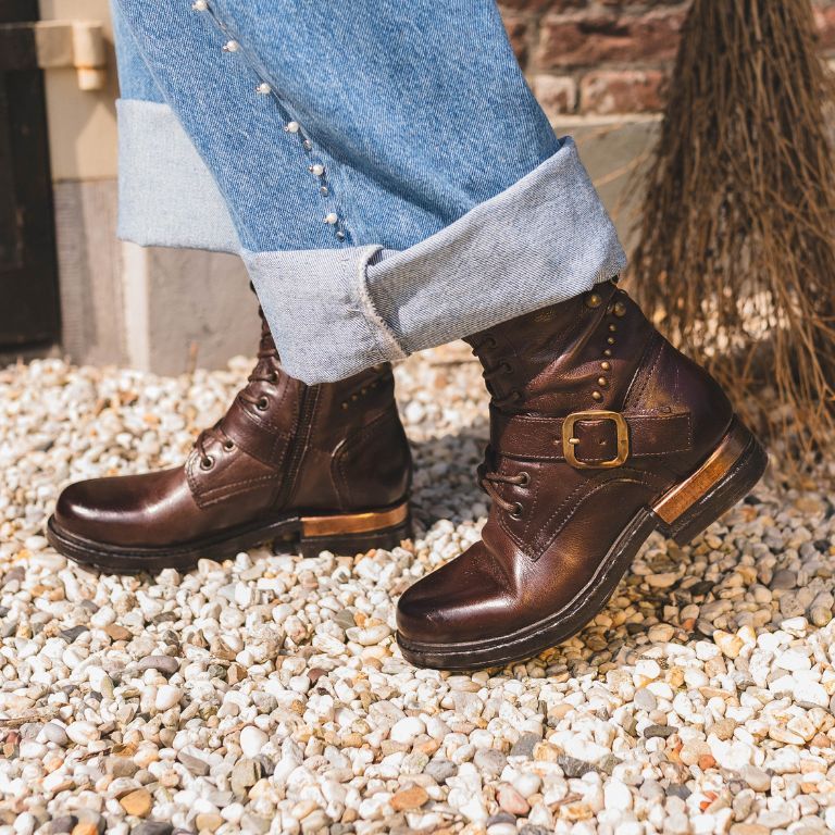 Westernlaarzen op een grintpad samen met een gevouwen lichte jeans