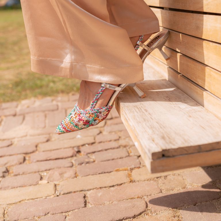 model loopt van een trapje met haar gekleurde raffia slingbacks