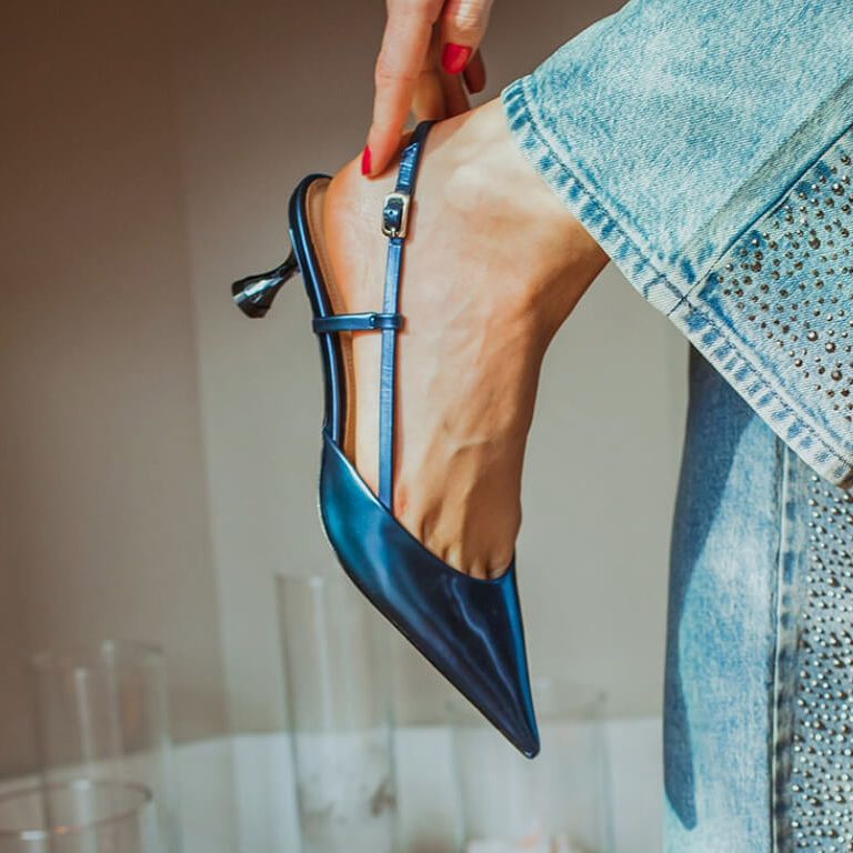 Close-up metallic blauwe pumps met kitten heel