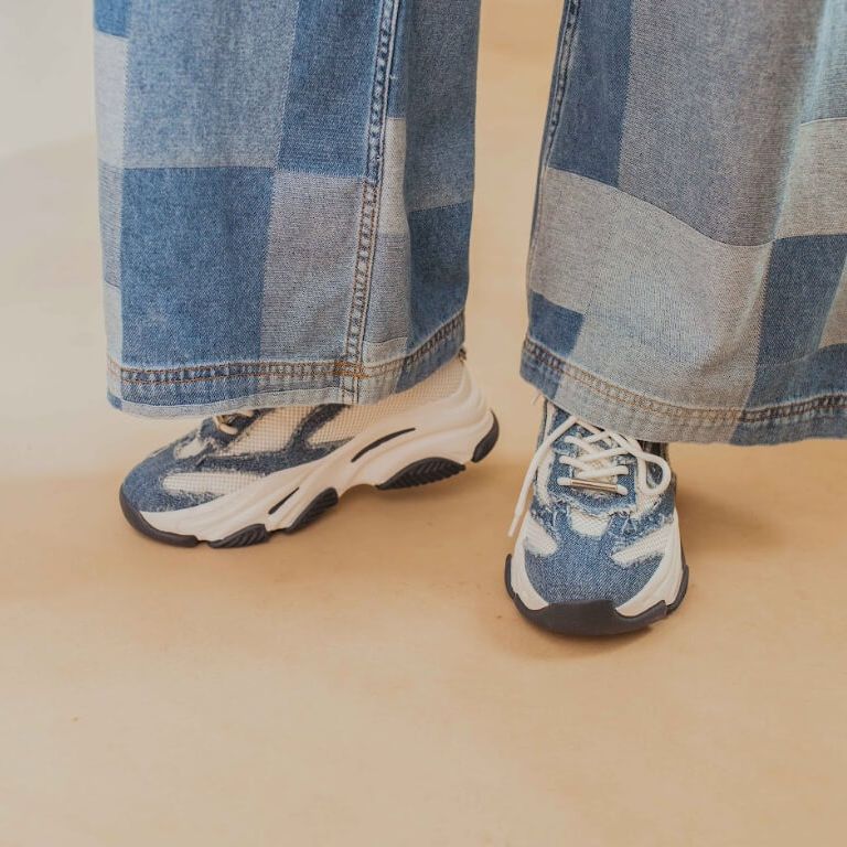 Witte sneakers met denim details onder geblokte spijkerbroek