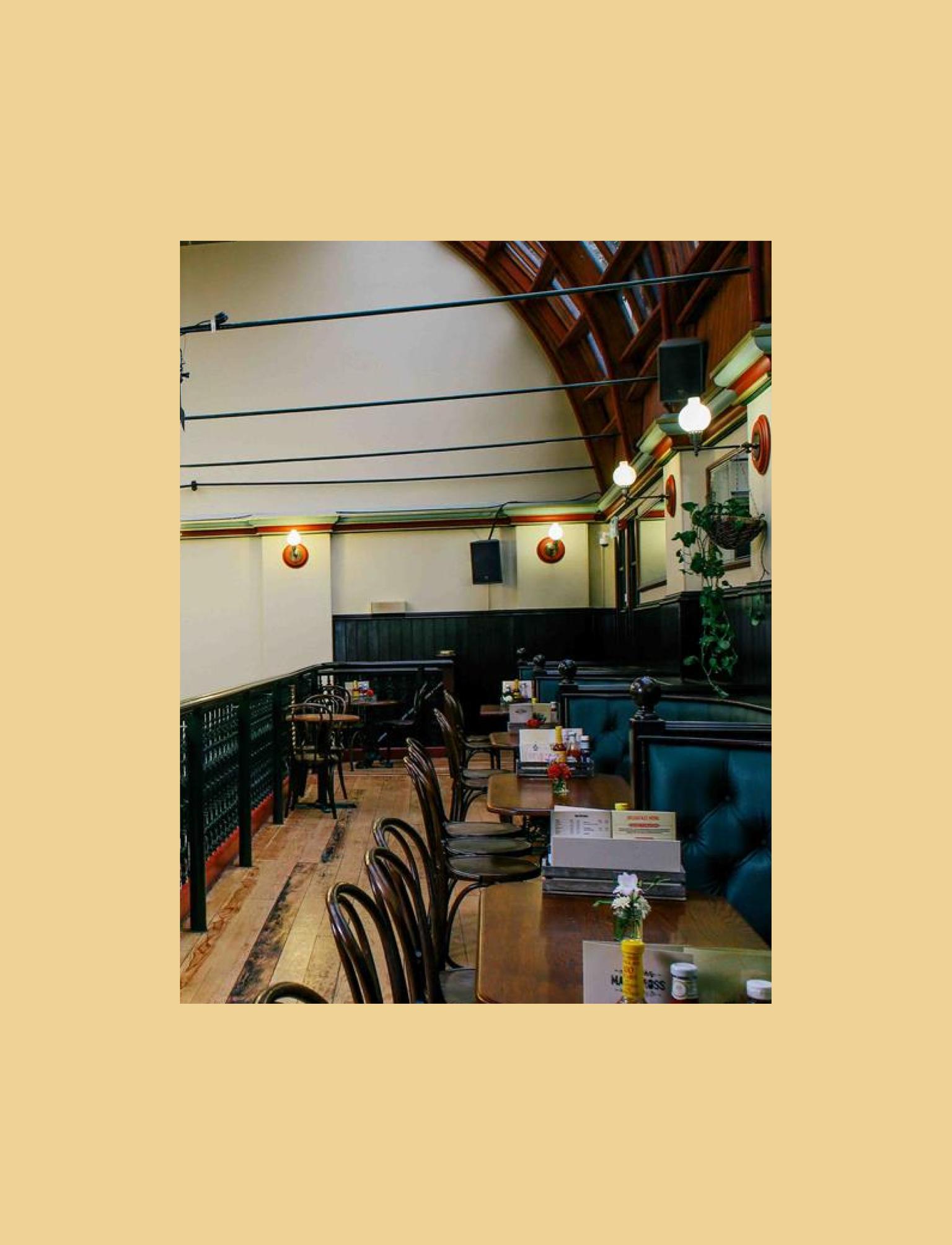 Spacious pub interior featuring a high arched ceiling and elegant balcony seating.
