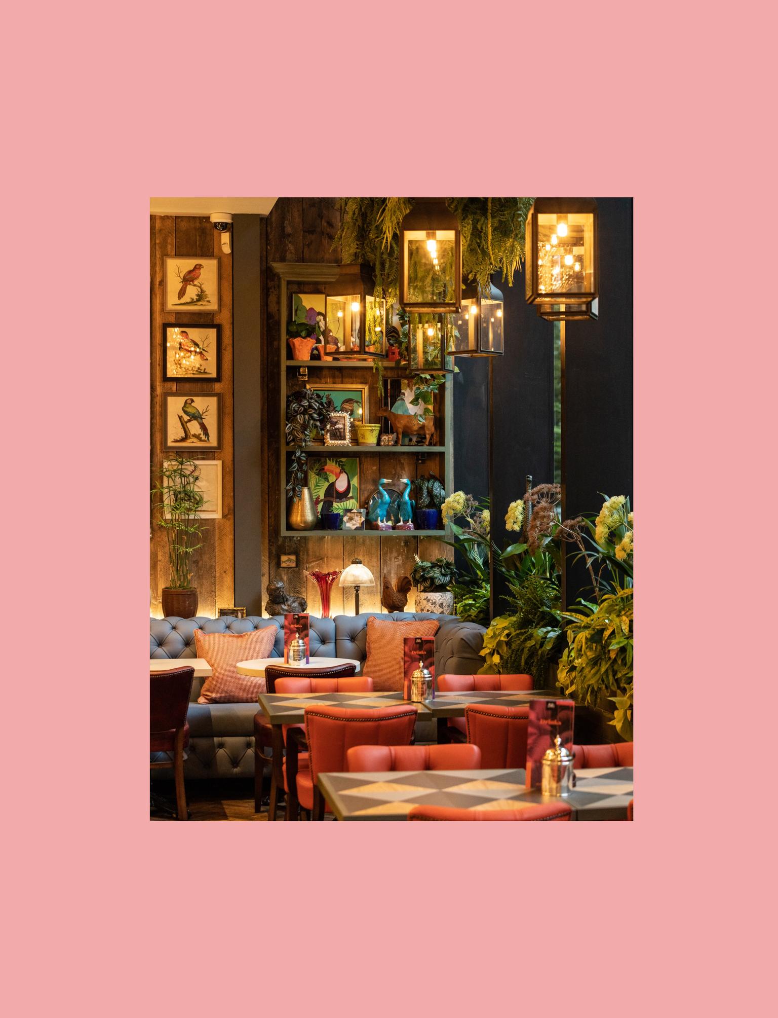 Restaurant with red leather chairs and plants for decoration.