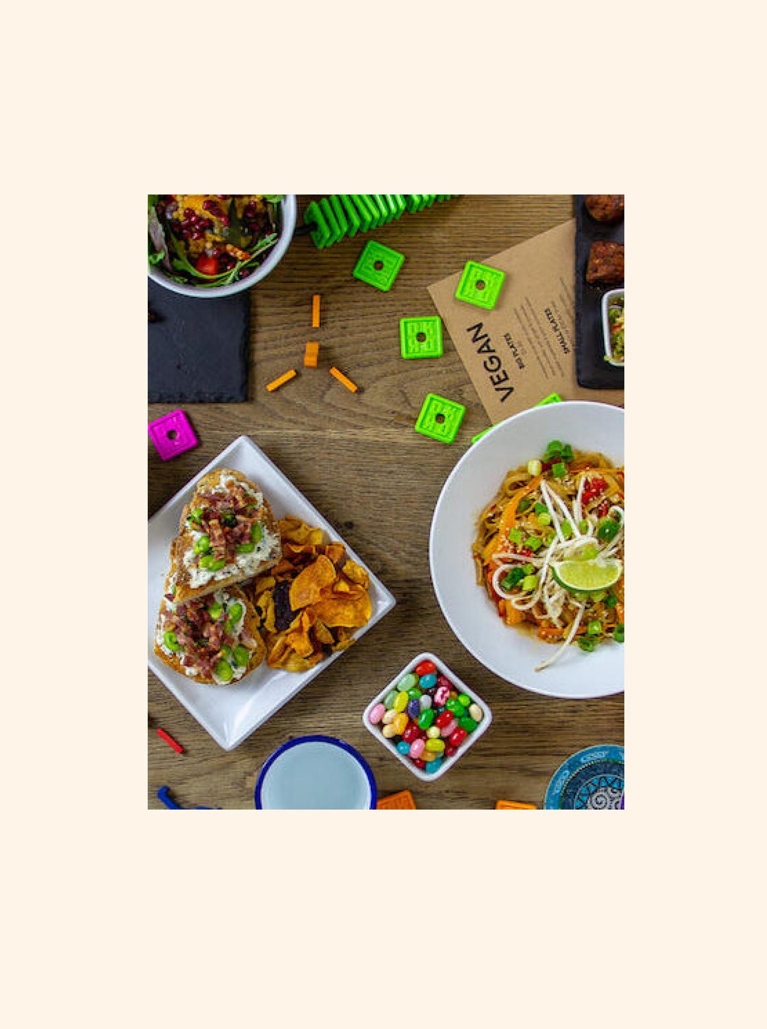 A mixture of food and board games on a table