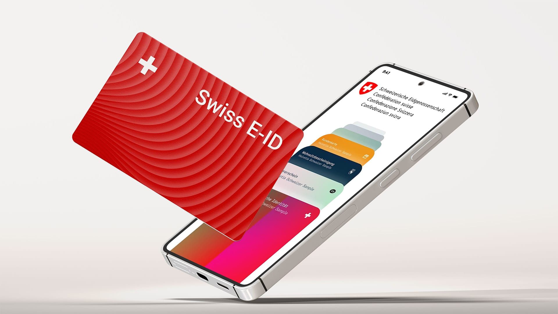 Ein Handy, auf dessen Bildschirm die Seite der Schweizerischen Eidgenossenschaft (admin.ch) zu sehen ist. Neben dem Handy eine Kreditkartengrosse, rote Karte mit Schweizerkreuz und dem Schriftzug "Swiss E-ID".
