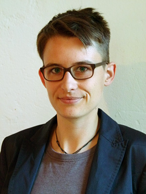 Porträt von einer Person mit braunen kurzen Haaren und einer Brille.