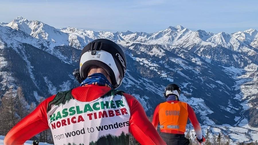 Marc Bleiker von hinten am Start eines Rennens. Vor ihm leuchtet die orange Weste des Guides.