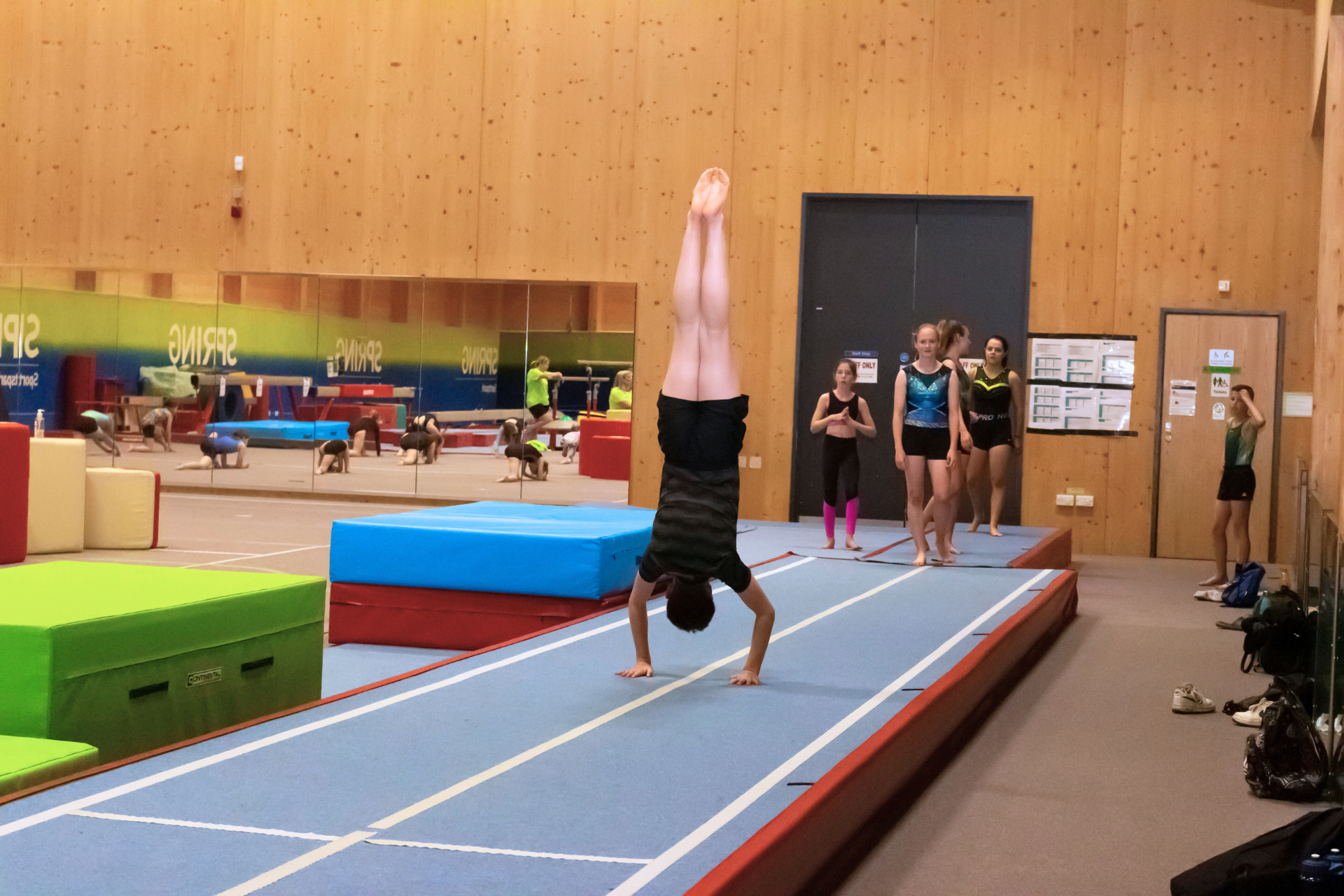 Boy doing a handstand in gymnastics centre.