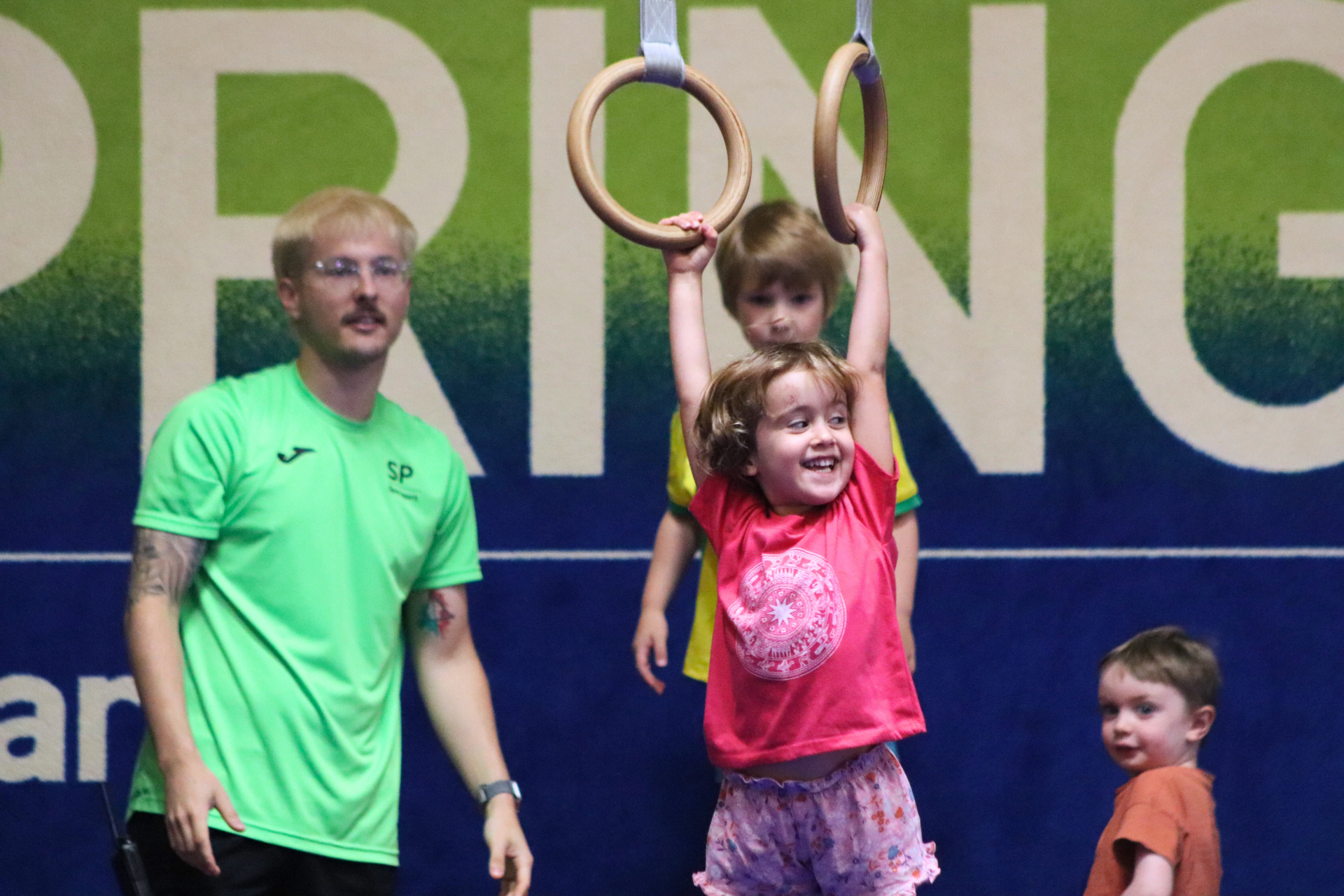 young girl swinging on gymnastics rings